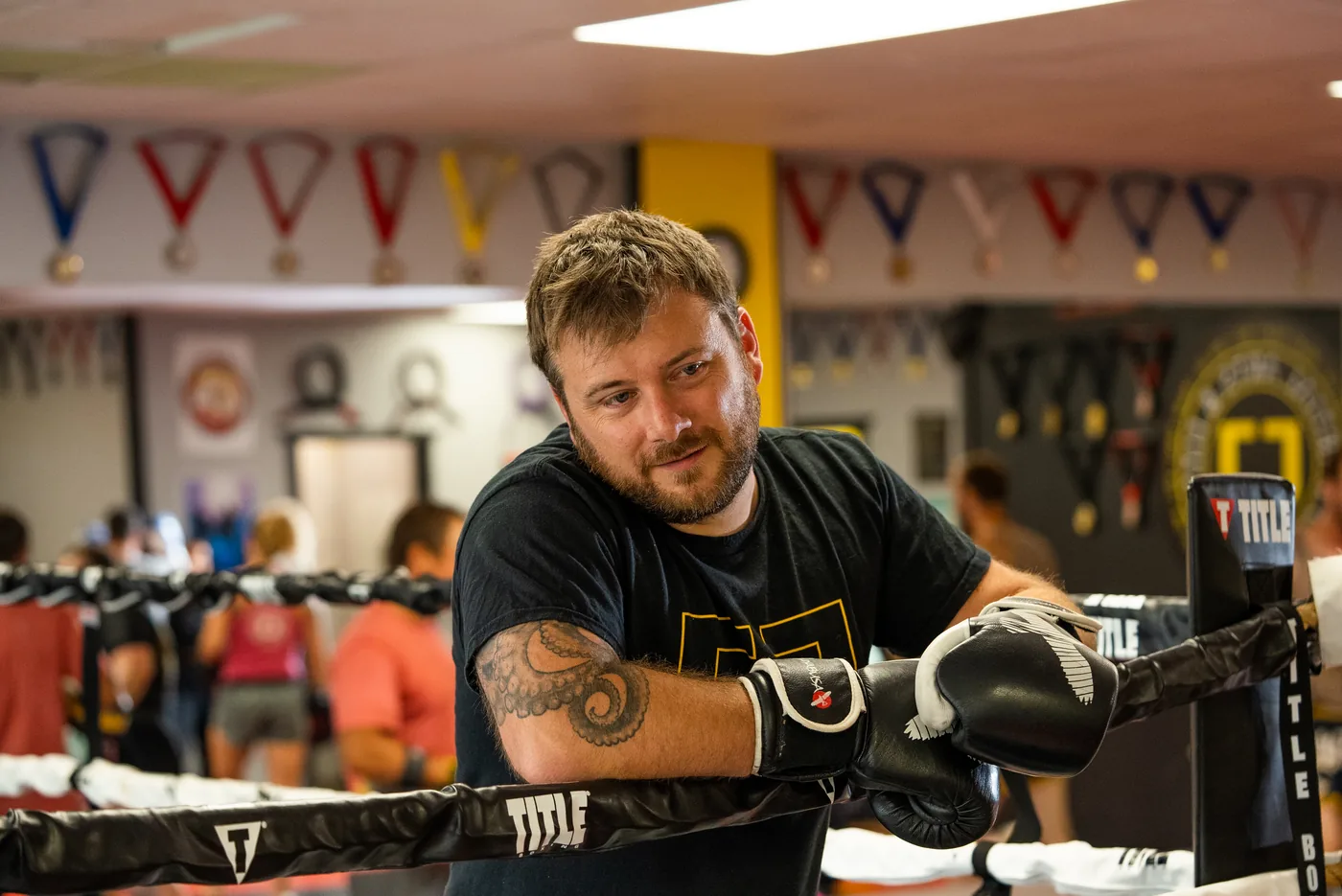 Jordy Denney leaning on the ropes of the boxing ring at CJ Martial Arts.